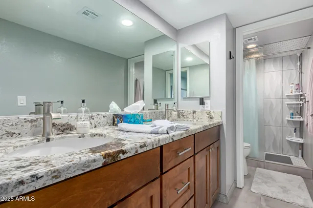 a bathroom with a granite countertop sink and a mirror