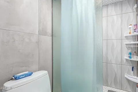 a bathroom with a toilet and a shower curtain