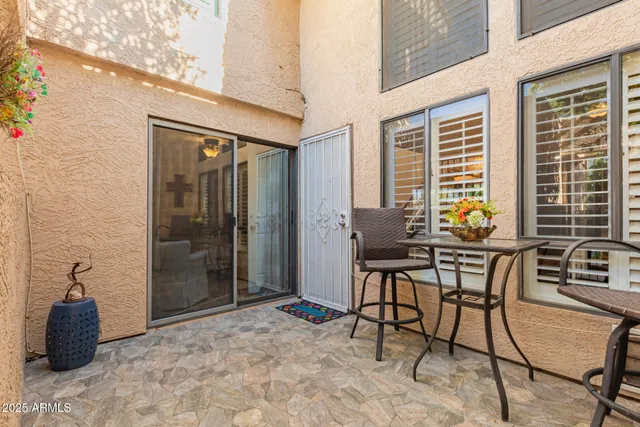 a view of a patio with table and chairs and potted plants