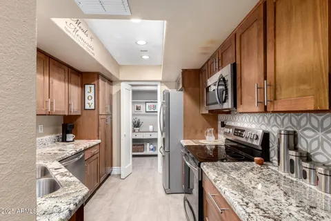 a kitchen with stainless steel appliances kitchen island granite countertop a stove and a sink