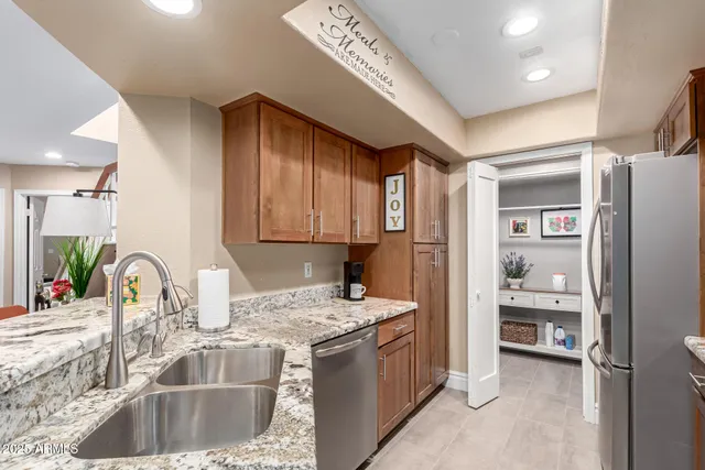 a kitchen with stainless steel appliances granite countertop a sink stove and refrigerator