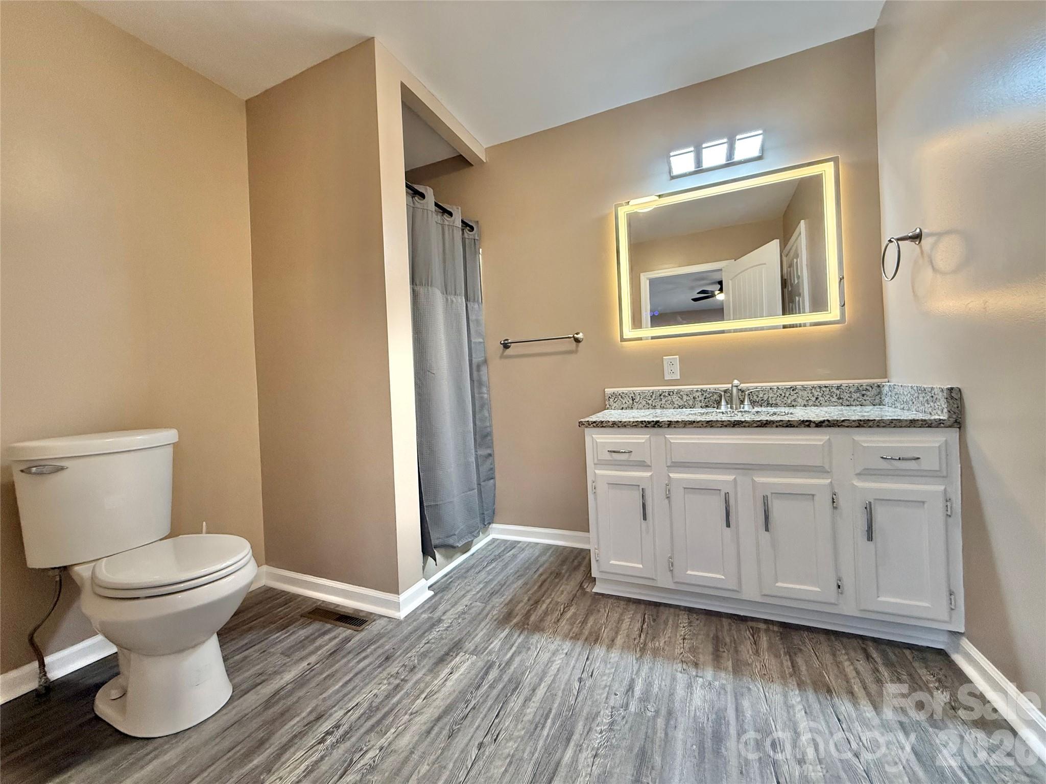 878 Stanback Ferry Road Lilesville, NC 28091 - Photo 13 of 19 a bathroom with a granite countertop toilet a sink and a mirror