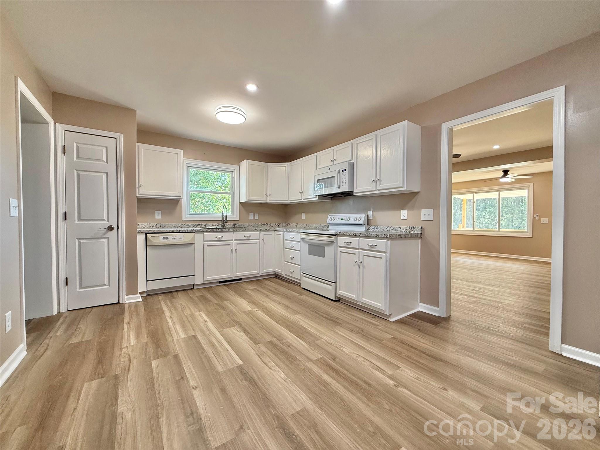 878 Stanback Ferry Road Lilesville, NC 28091 - Photo 9 of 19 a kitchen with white cabinets and stainless steel appliances