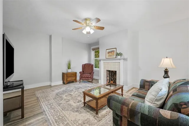 a dining room with wooden floor a chandelier fan a wooden table and chairs