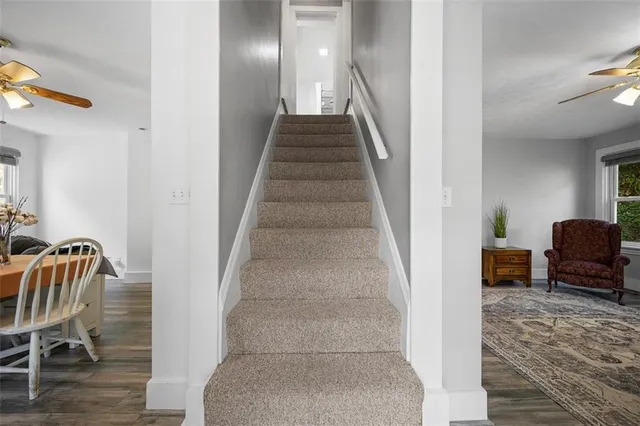a bedroom with a bed couch chandelier and window