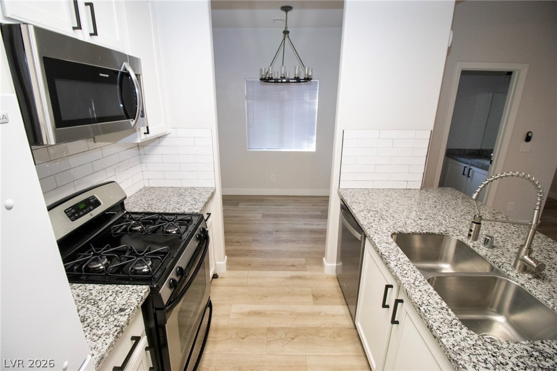 1468 Reef Ridge Court Las Vegas, NV 89128 - Photo 5 of 22 Modern kitchen with granite countertops and sleek appliances, perfect for entertaining.