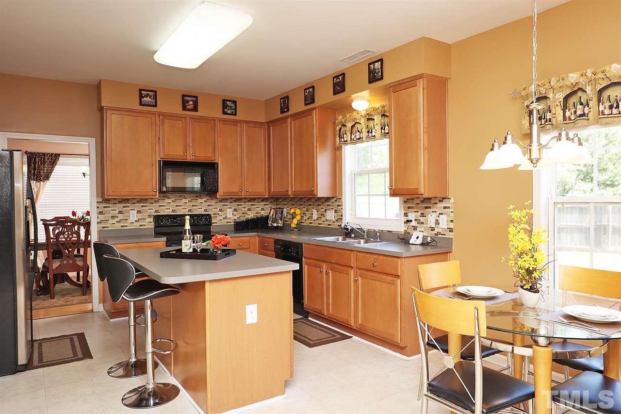 2616 Dality Drive Raleigh, NC 27604 - Photo 13 of 25 a kitchen with stainless steel appliances granite countertop a sink a stove a refrigerator cabinets and chairs