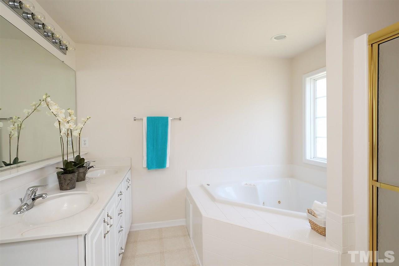 2616 Dality Drive Raleigh, NC 27604 - Photo 21 of 25 a bathroom with a tub sink and mirror