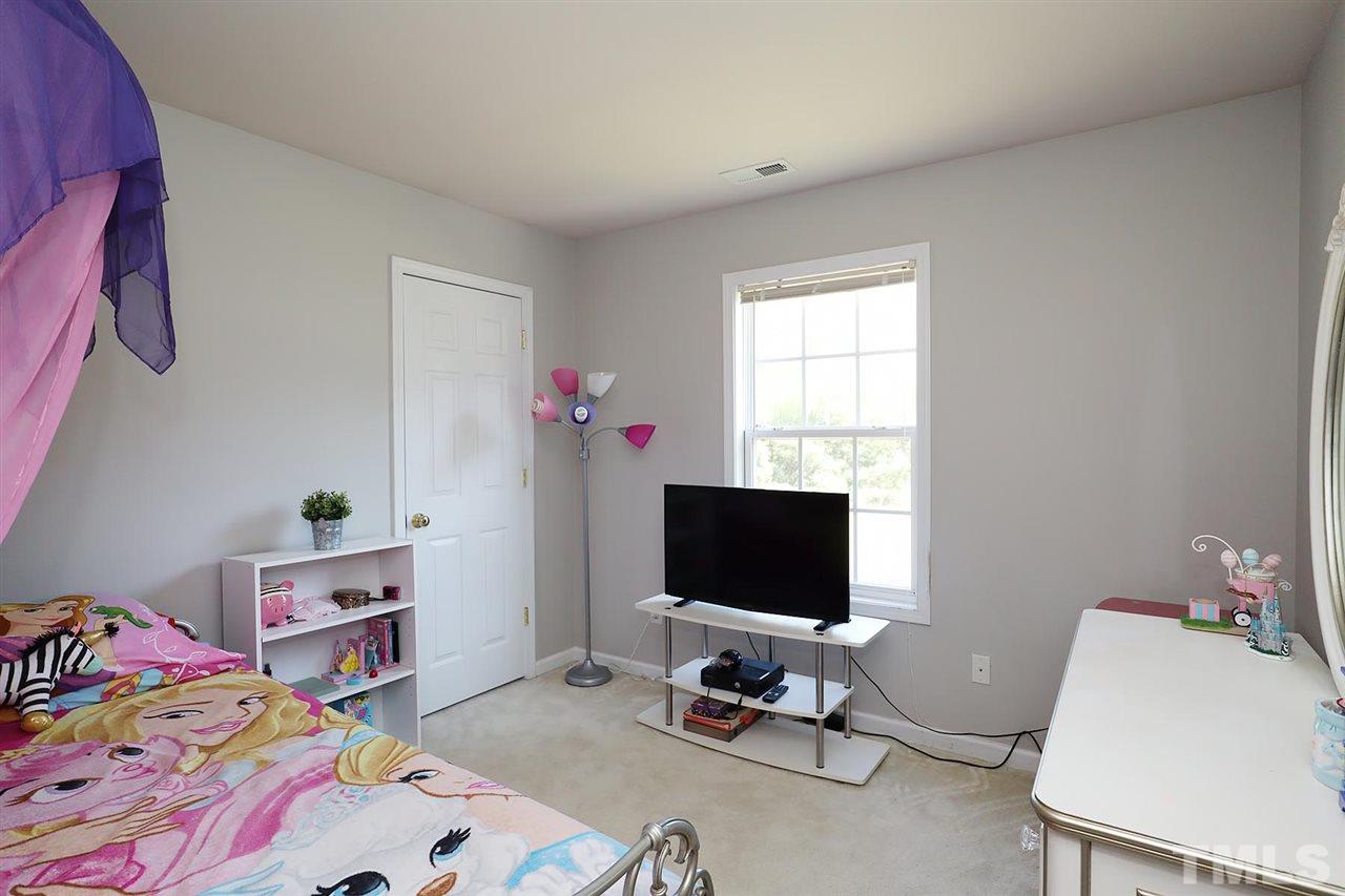 2616 Dality Drive Raleigh, NC 27604 - Photo 22 of 25 a bedroom with a bed and a chair in it