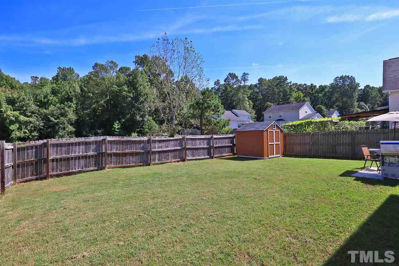 2616 Dality Drive Raleigh, NC 27604 - Photo 25 of 25 a view of a backyard with seating area and trees in the background