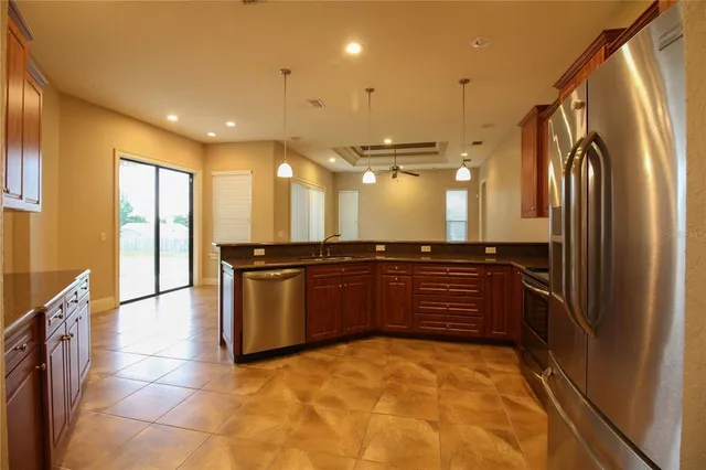 a kitchen with stainless steel appliances granite countertop a refrigerator and a sink