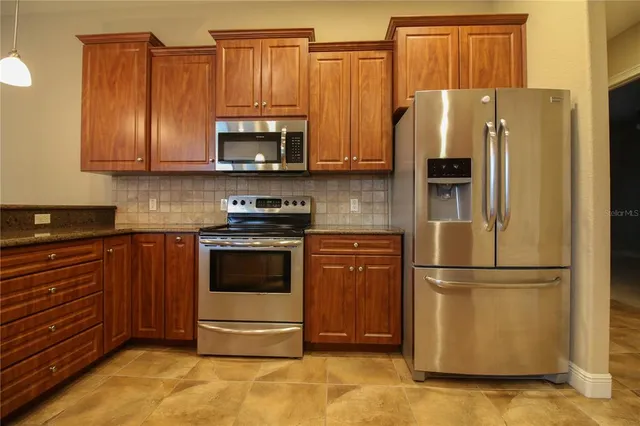 a kitchen with stainless steel appliances granite countertop a refrigerator stove and microwave