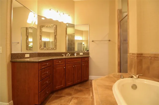 a bathroom with a tub sink and mirror