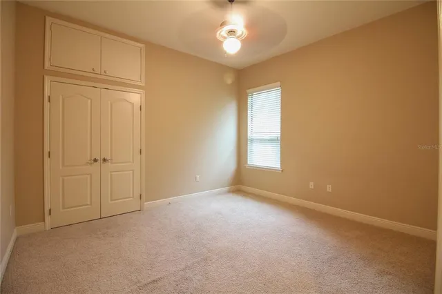 an empty room with windows and cabinet