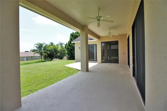 a view of a porch with a big yard and large tree