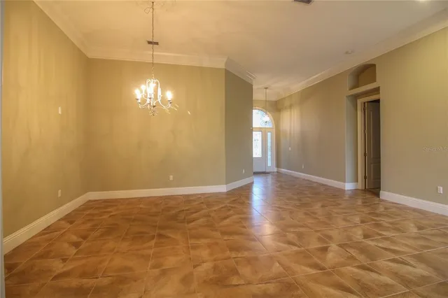 a view of an empty room with a chandelier fan