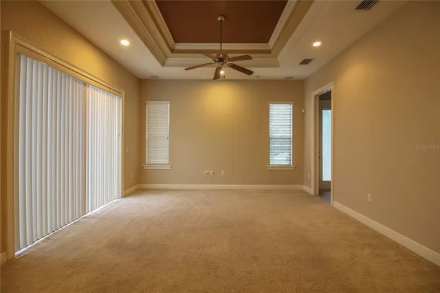 en empty room with windows and ceiling fan