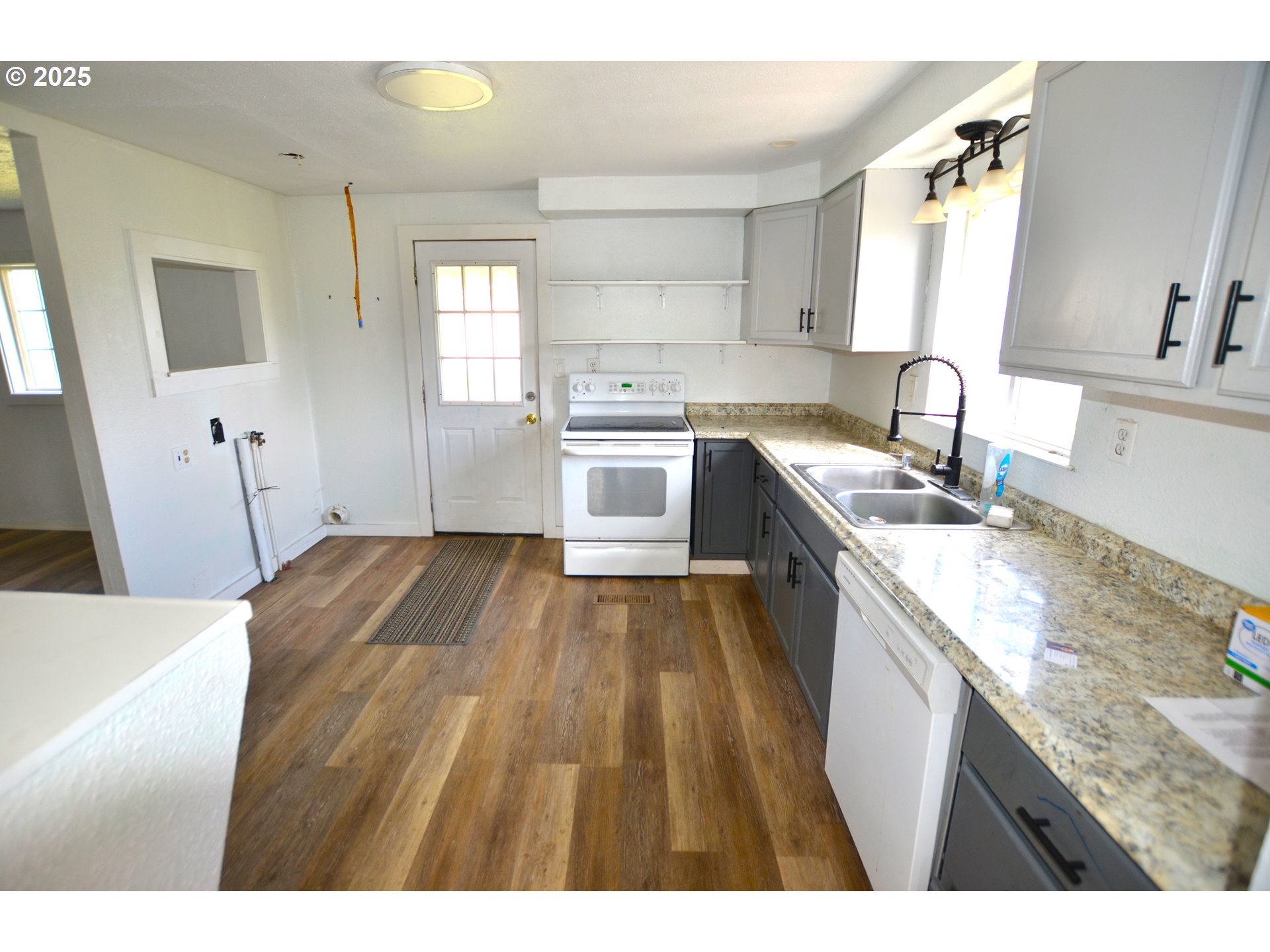 520 Northeast 4th Street Pilot Rock, OR 97868 - Photo 7 of 28 a kitchen with a sink cabinets wooden floor and stainless steel appliances