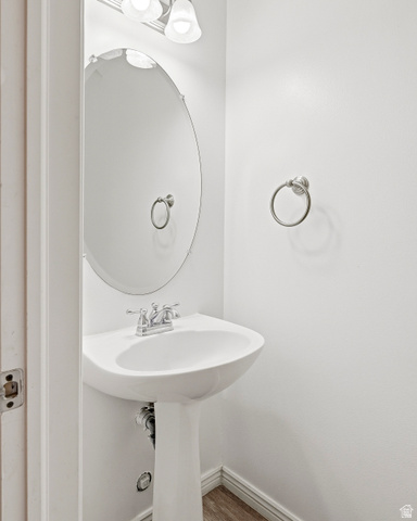 1177 Northfield Road, Unit 26 Cedar City, UT 84721 - Photo 18 of 45 Pedestal sink with chrome faucet, oval mirror, and wall-mounted light fixture