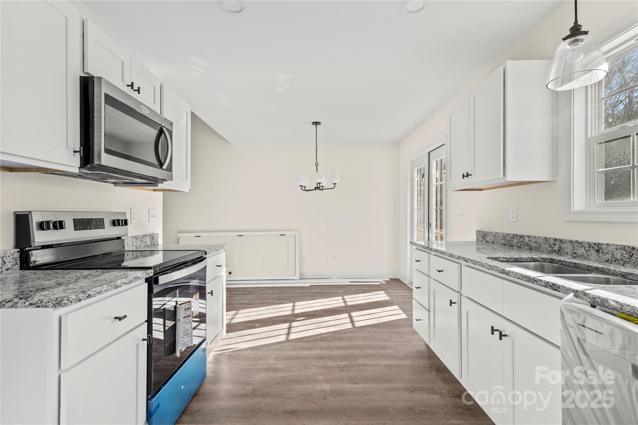 545 Washington Street Rock Hill, SC 29730 - Photo 12 of 25 a kitchen with stainless steel appliances granite countertop a stove a sink and a microwave