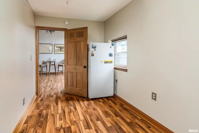 a view of a kitchen with wooden floor and a refrigerator