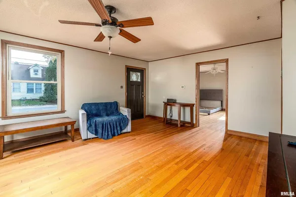 a livingroom with furniture a ceiling fan and wooden floor