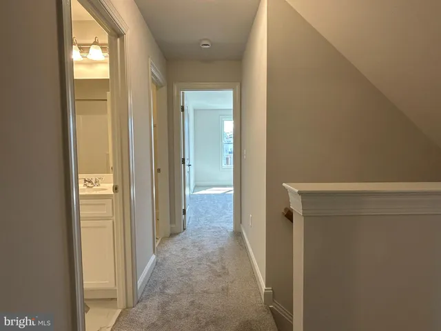a view of a hallway with wooden floor and closet