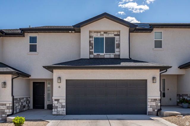668 East Fiddlers Canyon Road, Unit 6 Cedar City, UT 84721 - Photo 1 of 36 Stucco exterior featuring stone accents, a dark garage door, and a black front door