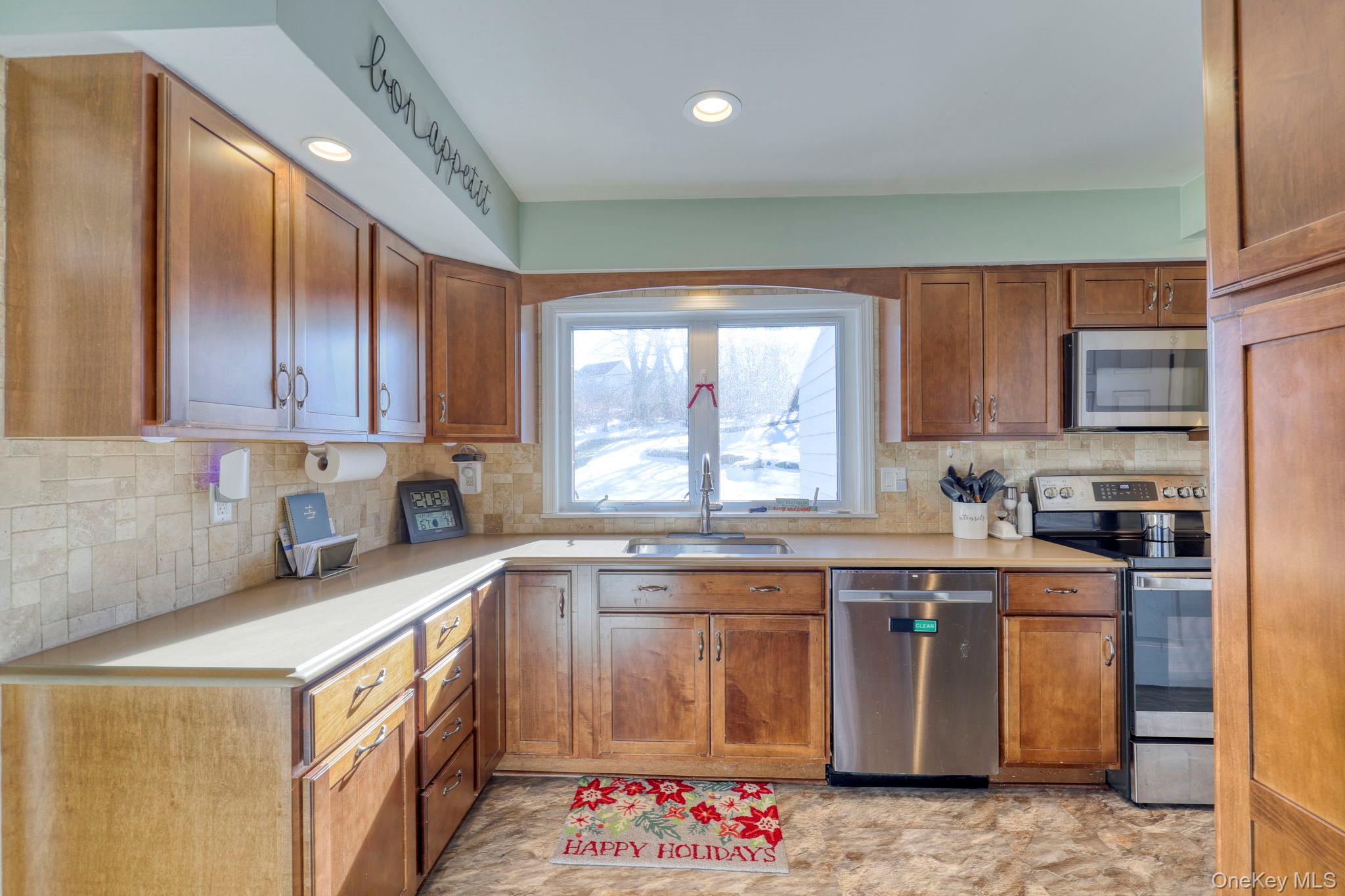 210 Overlook Road Poughkeepsie, NY 12603 - Photo 3 of 43 Kitchen featuring appliances with stainless steel finishes, brown cabinets, light countertops, backsplash, and recessed lighting