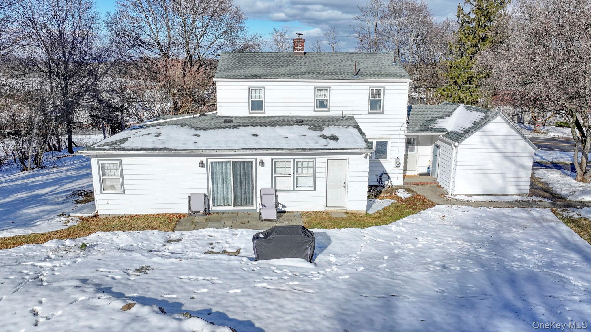 210 Overlook Road Poughkeepsie, NY 12603 - Photo 35 of 43 Snow covered back of property featuring roof with shingles, a chimney, and a patio