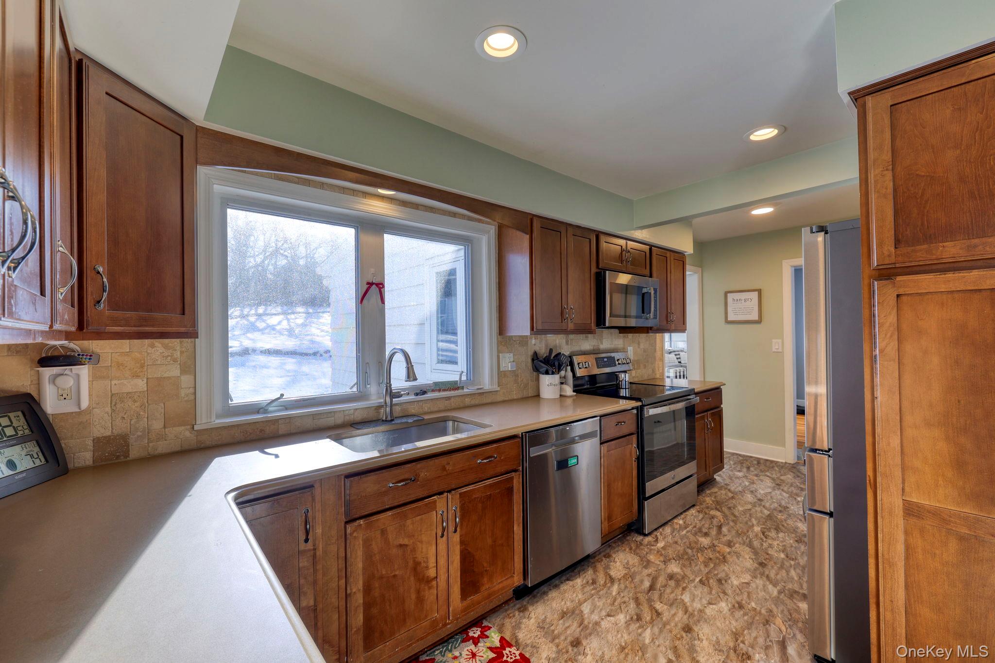 210 Overlook Road Poughkeepsie, NY 12603 - Photo 4 of 43 Kitchen with appliances with stainless steel finishes, backsplash, recessed lighting, light countertops, and brown cabinetry
