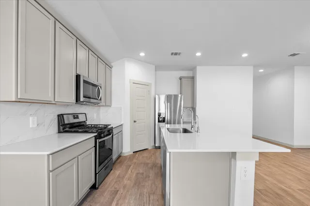 a kitchen with stainless steel appliances granite countertop a sink stove and refrigerator
