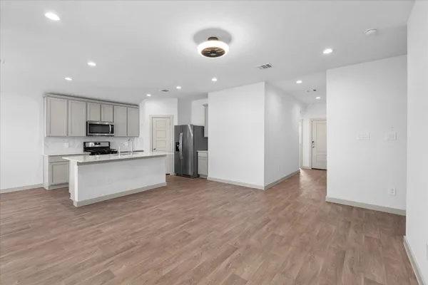 a view of kitchen with refrigerator sink and white cabinets