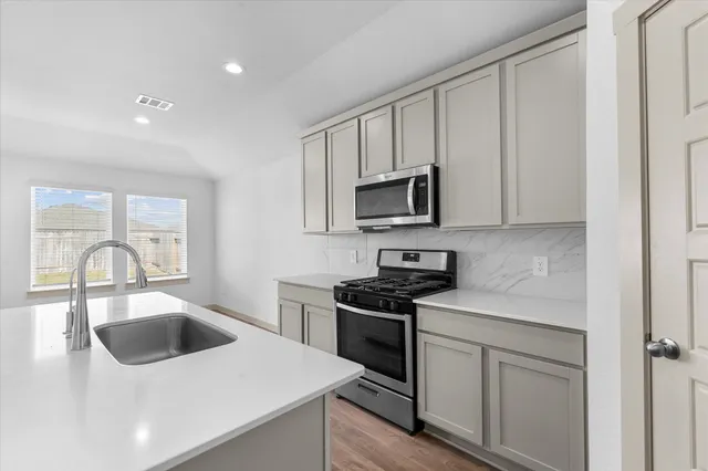 a kitchen with white cabinets and appliances