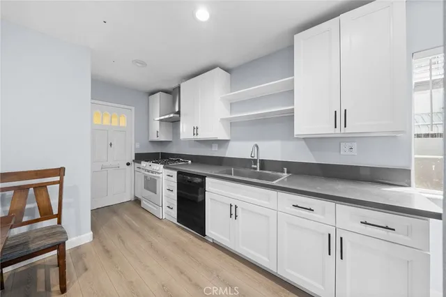 a kitchen with granite countertop white cabinets and white appliances