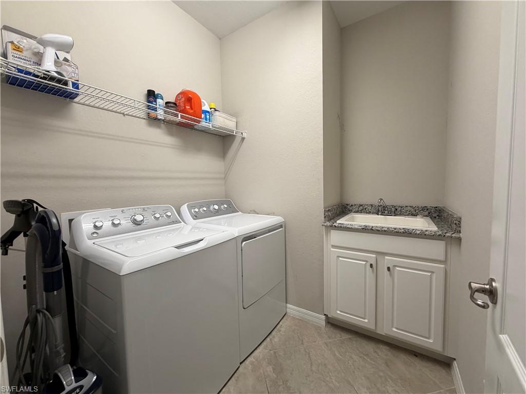 4284 Raffia Palm Circle Naples, FL 34119 - Photo 15 of 50 Laundry room featuring separate washer and dryer, cabinet space, and light tile patterned floors