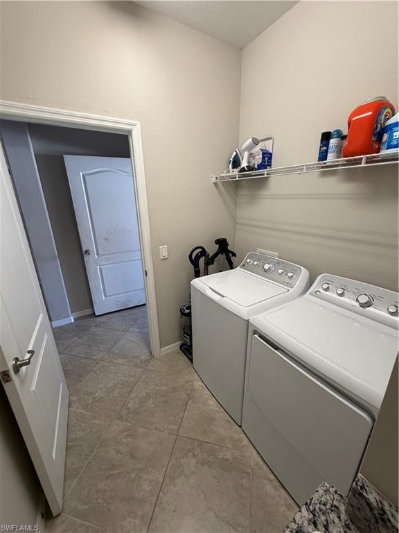 4284 Raffia Palm Circle Naples, FL 34119 - Photo 16 of 50 Laundry area with washing machine and clothes dryer and baseboards