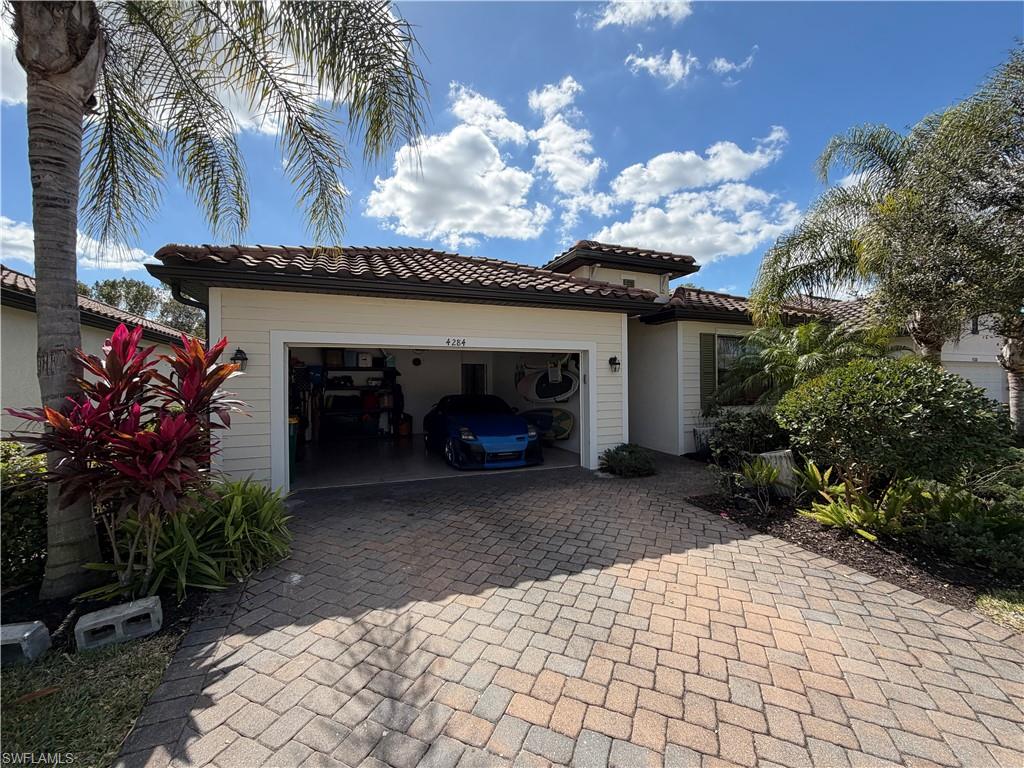 4284 Raffia Palm Circle Naples, FL 34119 - Photo 17 of 50 View of front of home featuring decorative driveway, a tile roof, and a garage