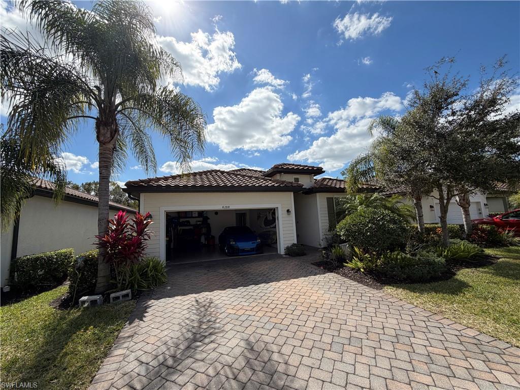 4284 Raffia Palm Circle Naples, FL 34119 - Photo 20 of 50 View of front facade with decorative driveway, a tile roof, and a garage