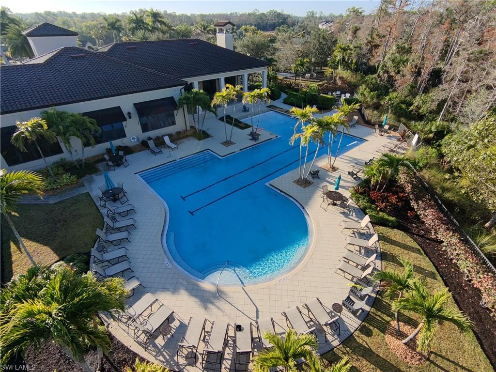4284 Raffia Palm Circle Naples, FL 34119 - Photo 21 of 50 Community pool with a patio and view of wooded area