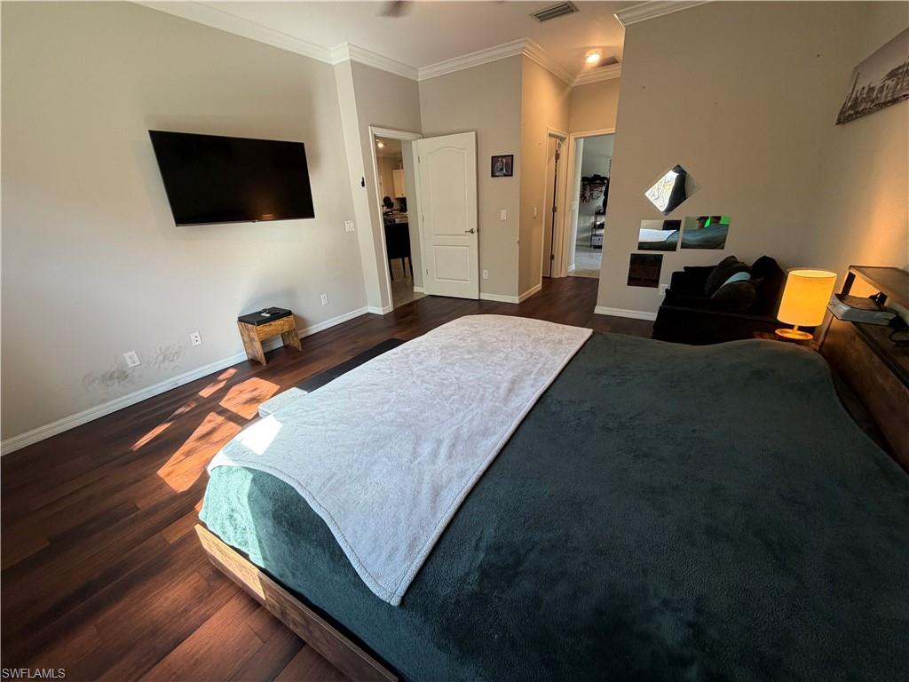 4284 Raffia Palm Circle Naples, FL 34119 - Photo 28 of 50 Master Bedroom with dark wood-style flooring, crown molding, and a ceiling fan