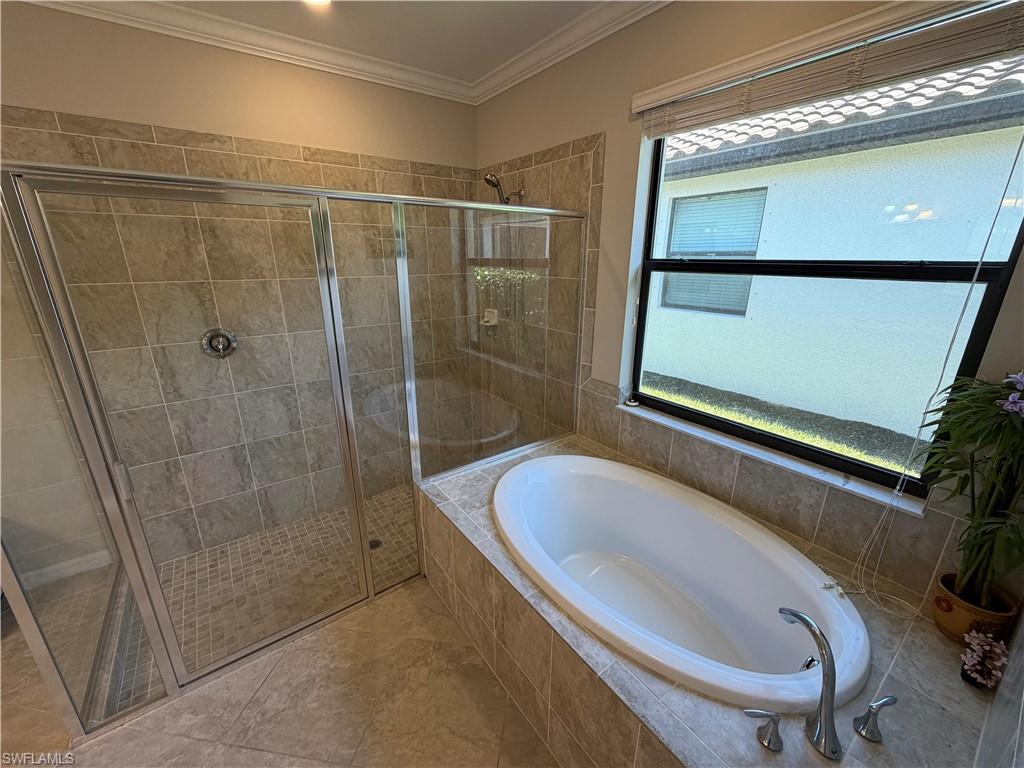 4284 Raffia Palm Circle Naples, FL 34119 - Photo 37 of 50 Full bath featuring a bath, a stall shower, and crown molding