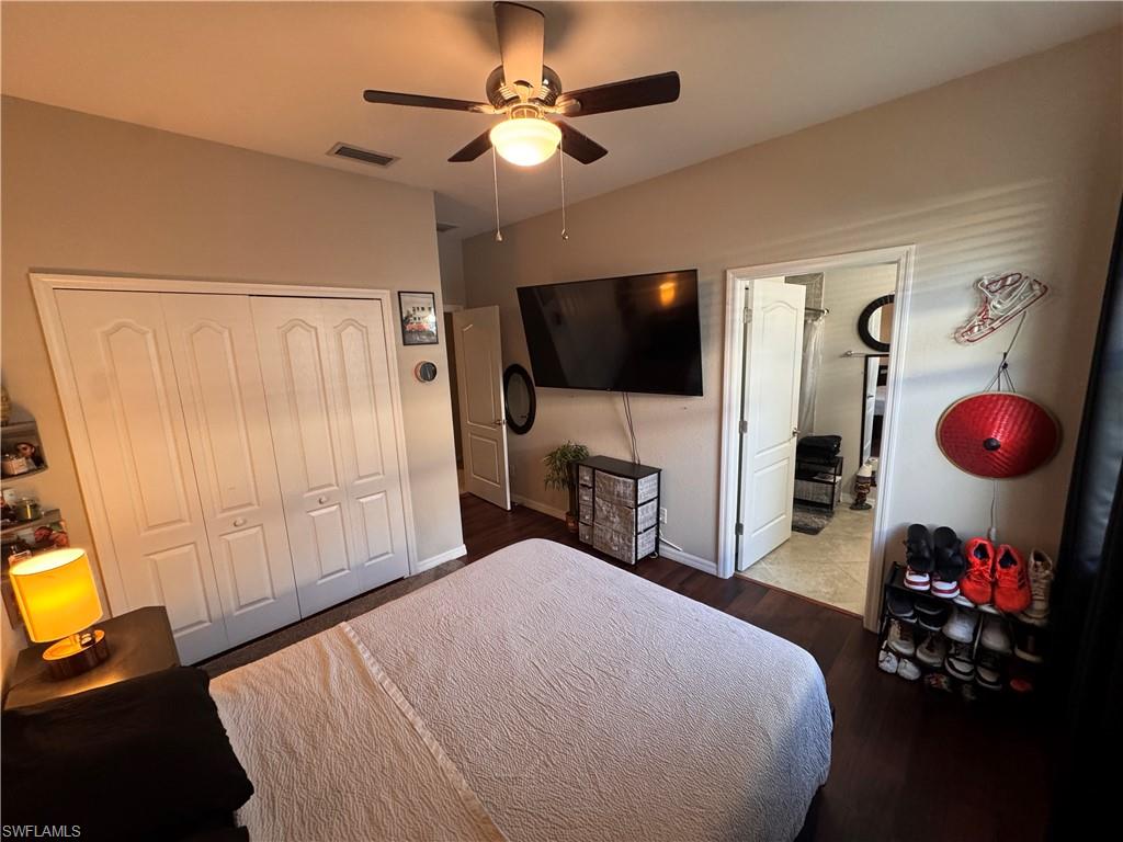 4284 Raffia Palm Circle Naples, FL 34119 - Photo 42 of 50 Bedroom with wood finished floors, a closet, a ceiling fan, and connected bathroom