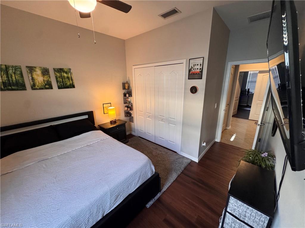 4284 Raffia Palm Circle Naples, FL 34119 - Photo 45 of 50 Bedroom featuring dark wood-style flooring, a closet, and ceiling fan