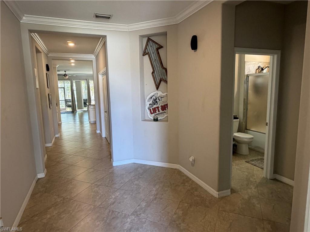 4284 Raffia Palm Circle Naples, FL 34119 - Photo 8 of 50 Hallway featuring ornamental molding and baseboards