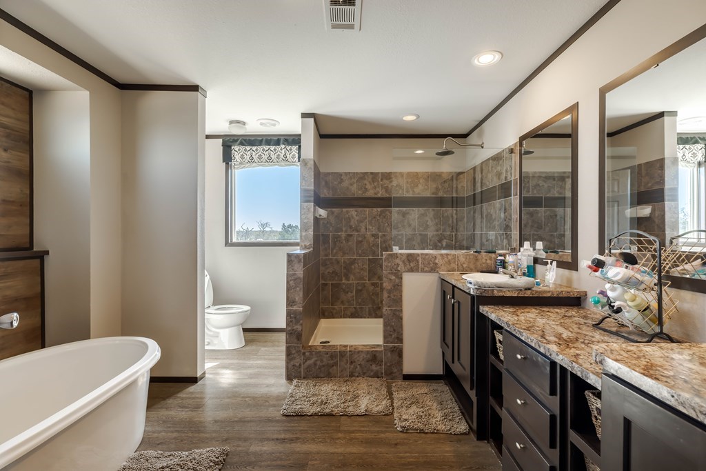 192 Chuckwagon Trail Harper, TX 78631 - Photo 11 of 23 a bathroom with a granite countertop sink a toilet a mirror and bathtub
