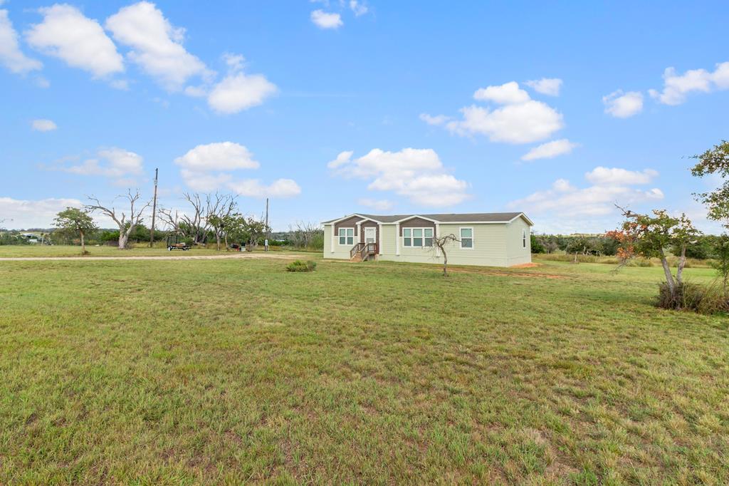192 Chuckwagon Trail Harper, TX 78631 - Photo 13 of 23 a front view of a house with a lake