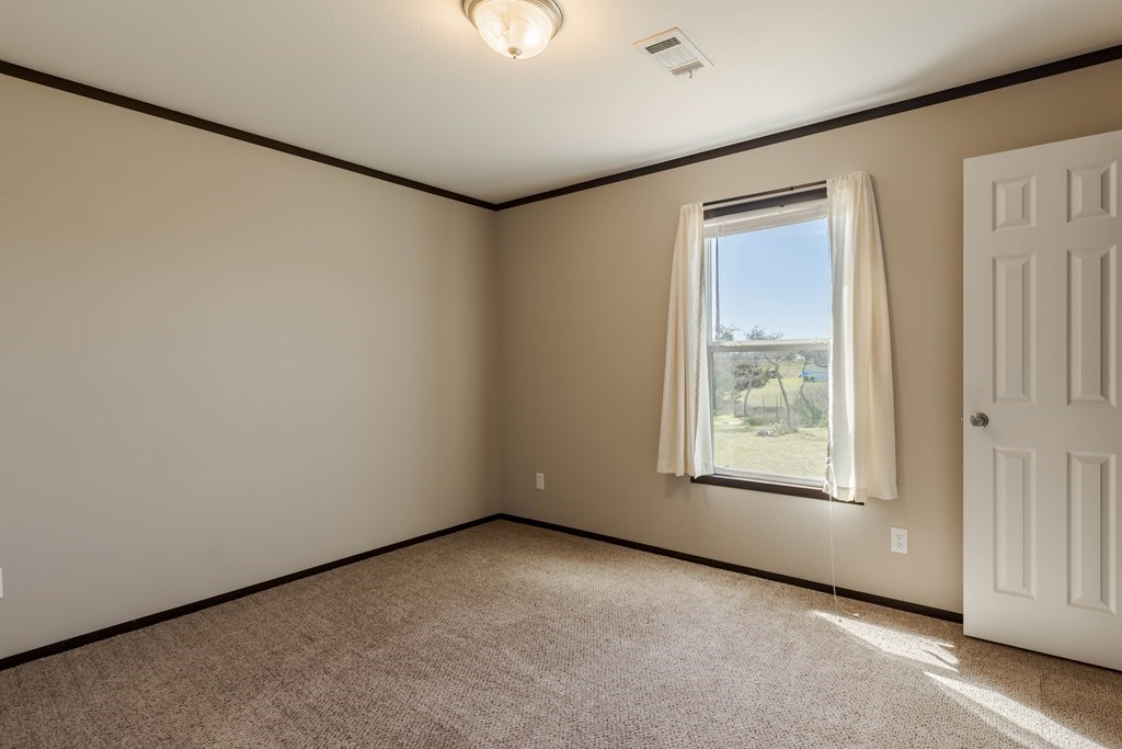 192 Chuckwagon Trail Harper, TX 78631 - Photo 4 of 23 an empty room with windows