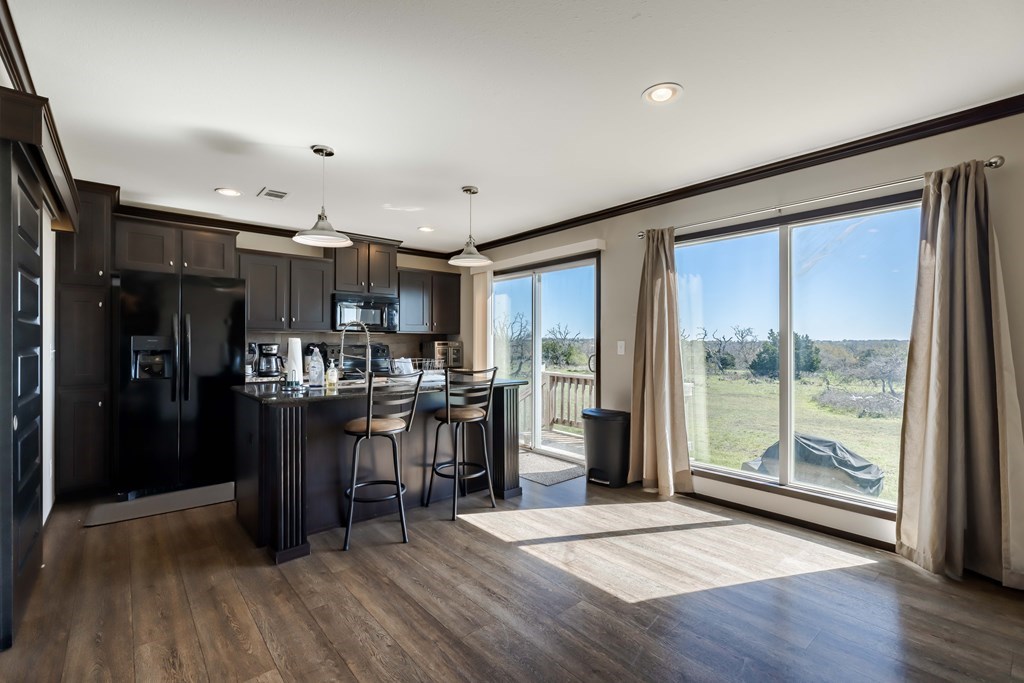 192 Chuckwagon Trail Harper, TX 78631 - Photo 7 of 23 a view of a kitchen with furniture and wooden floor