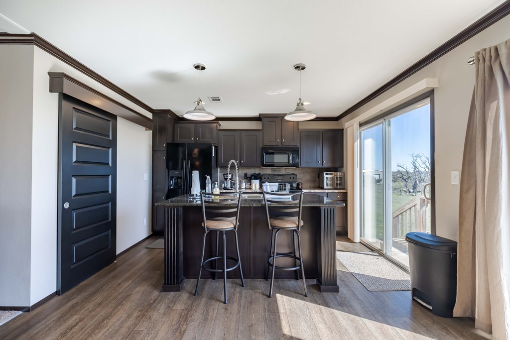 192 Chuckwagon Trail Harper, TX 78631 - Photo 8 of 23 a kitchen with stainless steel appliances a dining table chairs stove and refrigerator